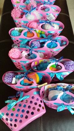 a table topped with lots of pink baskets filled with toys