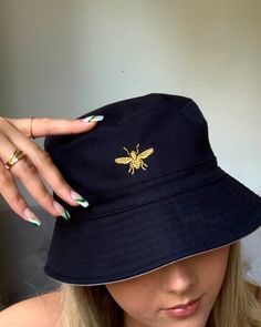 Colour customisable bee embroidered bucket hats. They are a standard sizing of S/M and are available in reversible style olive green/beige, grey/black or navy/white (please note once they are embroidered they are no longer reversible as the embroidery shows through the other side). I also have limited availability of hats in size L/XL, please message if you would like this size instead. Please fill out the customisation as follows: Primary colour: Outer hat colour e.g. Black Secondary colour: Be Black Wide Brim Hat With Embroidered Logo, Black Bucket Hat With Embroidered Logo, Black Embroidered Logo Bucket Hat For Summer, Chloe Johnson, Rave Hats, Secondary Colour, Festival Rave Outfit, Embroidered Bucket Hat, Fisherman Hat