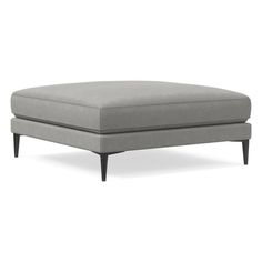 a gray ottoman sitting on top of a white floor