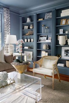 a living room filled with lots of furniture and bookshelves covered in blue paint