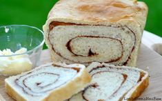 a loaf of cinnamon swirl bread sitting on top of a cutting board next to butter