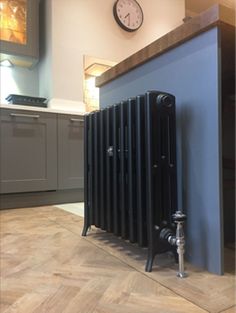 a radiator in the middle of a kitchen with a clock on the wall