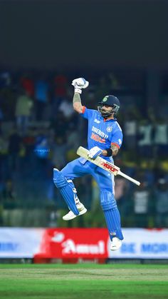 a cricket player jumping in the air with his bat