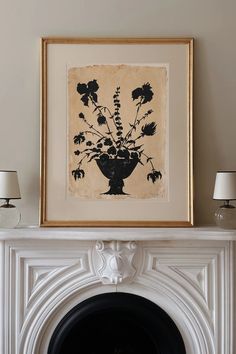 a white fireplace with a black and white vase on it's mantle next to two lamps