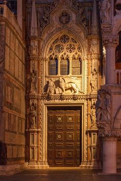 the entrance to an ornate building with carved doors