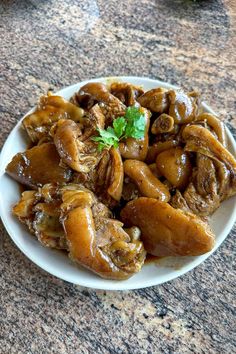 a white plate topped with meat covered in sauce