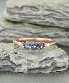 three stone ring sitting on top of a rock