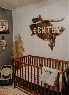 a baby's room with a deer head painted on the wall next to a crib