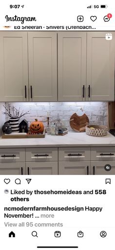 the kitchen is decorated for halloween with white cabinets and pumpkins on the counter top