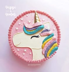 a pink cake with a unicorn face on it