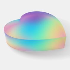 a pastel rainbow heart shaped pillow on a white background