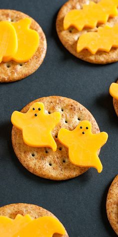 crackers decorated to look like ghost cookies with yellow icing on them, sitting on a baking sheet