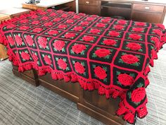 a bed with a red and black bedspread on top of it in a room