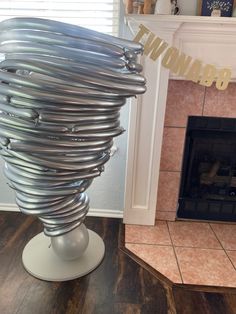 a large metal object sitting on top of a wooden floor next to a fire place