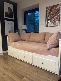 a living room with a couch and some drawers on the floor in front of a window