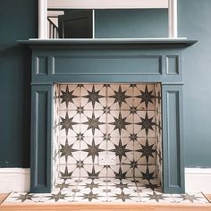 a fireplace in a room with a mirror on the wall above it and tiled floor