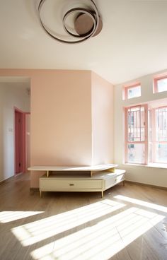 an empty room with pink walls and wooden floors