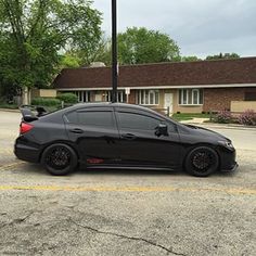 a black car is parked in the parking lot