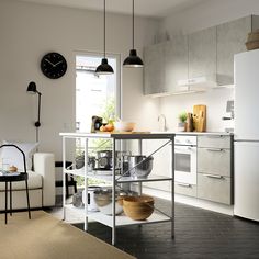 a kitchen area with a table, chairs and a clock on the wall above it