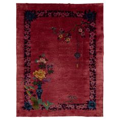 a red rug with flowers and vines on it