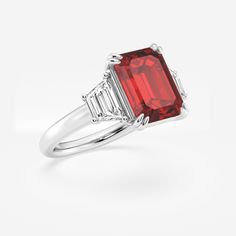 Get lost in the mesmerizing facets of this emerald cut three stone ring, featuring a striking red ruby that's sure to turn heads. The emerald cut's clean lines and geometric precision bring an enchanting shimmer to the vibrant gem, while its elongated shape creates an elegant look on the finger. Accented by diamond side stones, this emerald cut ruby ring embodies old world sophistication. Gia Certified Baguette Cut Ruby Ring, Luxury Emerald-cut Ruby Ring, Fine Jewelry Ruby Ring With Radiant Cut Center Stone, Radiant Cut Ruby Ring Fine Jewelry, Radiant Cut Ruby Ring In Fine Jewelry Style, Lab-created Ruby Baguette Cut Jewelry, Radiant Cut Ruby Ring With Center Stone, Asscher Cut Ruby Ring For Formal Occasions, Gia Certified Emerald Cut Ruby Ring