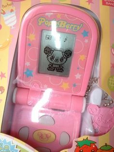 a pink toy cell phone with hello kitty on it's display case in a box