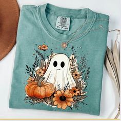 Ghost Shirt, Comfort Colors, Fall Ghost Shirt, Floral Ghost Shirt, Boho Ghost tshirt, Halloween Ghost, Funny Ghost, Fall Shirt, Autumn Shirt ☀️Popular Comfort Color 1717 tshirts ☀️Preshrunk, soft-washed, garment-dyed fabric ☀️Sizes: S-4X size up for an oversized tshirt fit. great for small business owners bridal parties  birthday shirts spring outfit nature lovers Christmas gifts Holiday Parties Care instructions: Machine wash cold inside out. Dry on low.  Shipping: Items will ship within 1-5 bu Fall Cotton Tops With Character Print, Cotton Tops With Character Print For Fall, Spooky Cotton Top For Fall, Spooky Cotton Tops For Fall, Blue Pre-shrunk Tops For Halloween, Fall Cotton Shirt With Cartoon Print, Green Cartoon Print Top For Fall, Green Cartoon Print Tops For Fall, Fun Custom Print Tops For Fall