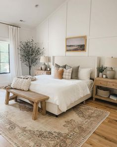 a bed room with a neatly made bed next to a window and a rug on the floor