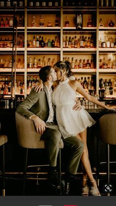 a man and woman sitting in front of a bar