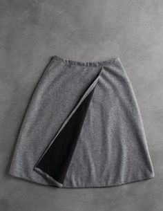 a grey skirt with a black pocket on the front and side, against a gray background