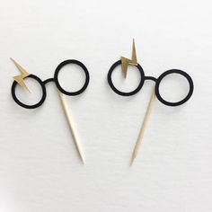 two harry potter's wands with lightning bolt on them, sitting next to each other