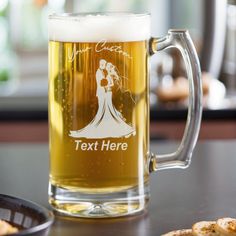 a beer mug sitting on top of a table next to crackers and a plate