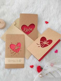 three valentine's day cards on a white furnishing with hearts and ribbons