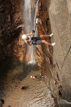 a man is rapping through the water while another person watches from behind him on a rope