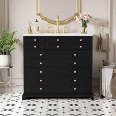 a black dresser with gold knobs in a white room next to a mirror and potted plant