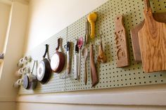 there are many different types of utensils hanging on the wall next to each other