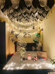 a table topped with lots of balloons and confetti next to a wall mounted clock