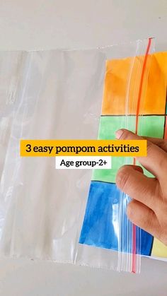 a hand holding a piece of paper with the words 3 easy pompom activities age group - 2 +