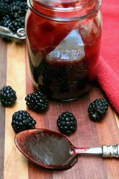 blackberries and raspberry jam in a jar with spoon