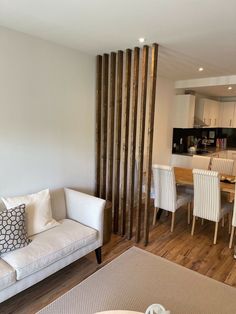 a living room filled with furniture next to a dining room table and kitchen counter top