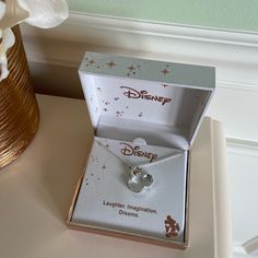 a disney necklace in a box on a table