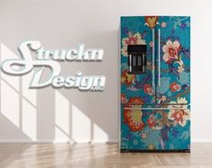 a blue refrigerator sitting in the middle of a room next to a wall with flowers on it