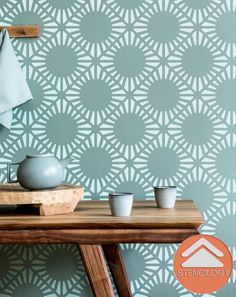 tea cups on a table in front of a wallpaper