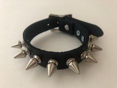 a black leather bracelet with metal spikes on it