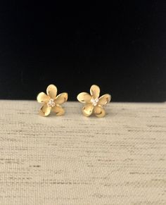 "Solid .925 Sterling Silver w/ 14K Gold Overlay Hawaiian Plumeria Flower 3-stone Stud Earrings. The size is larger at 18MM, just under 3/4\". They have a matte center with high-polished edges w/ three tiny cubic zirconias for a touch of bling. The Gold over the Sterling finish is both stunning, durable and nickel-free. Designed to mimic the look of fine jewelry at a fraction of the cost. --The Plumeria is iconic of Hawaiian culture. It's bright colors and magnificent scent greet both visitors an Gold Flower Earrings, Flower Earrings Gold, Hawaiian Plumeria, Hawaiian Culture, Hawaiian Jewelry, Gold Overlay, Earrings Flower, Stone Studs, Gold Flower