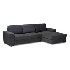 a gray sectional couch sitting on top of a white floor next to a black ottoman