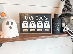 a shelf with halloween decorations on it and a sign that says our boo's