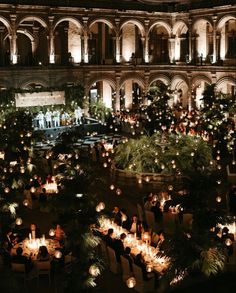 a large building with lots of lit up trees and candles in the middle of it