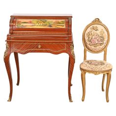 an antique desk and chair with paintings on it