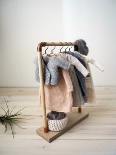 a clothes rack with several sweaters and slippers hanging from it's sides